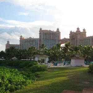 The iconic pink Atlantis Paradise Island resort towers rising above palm trees and manicured green lawns on Nassau, Bahamas.